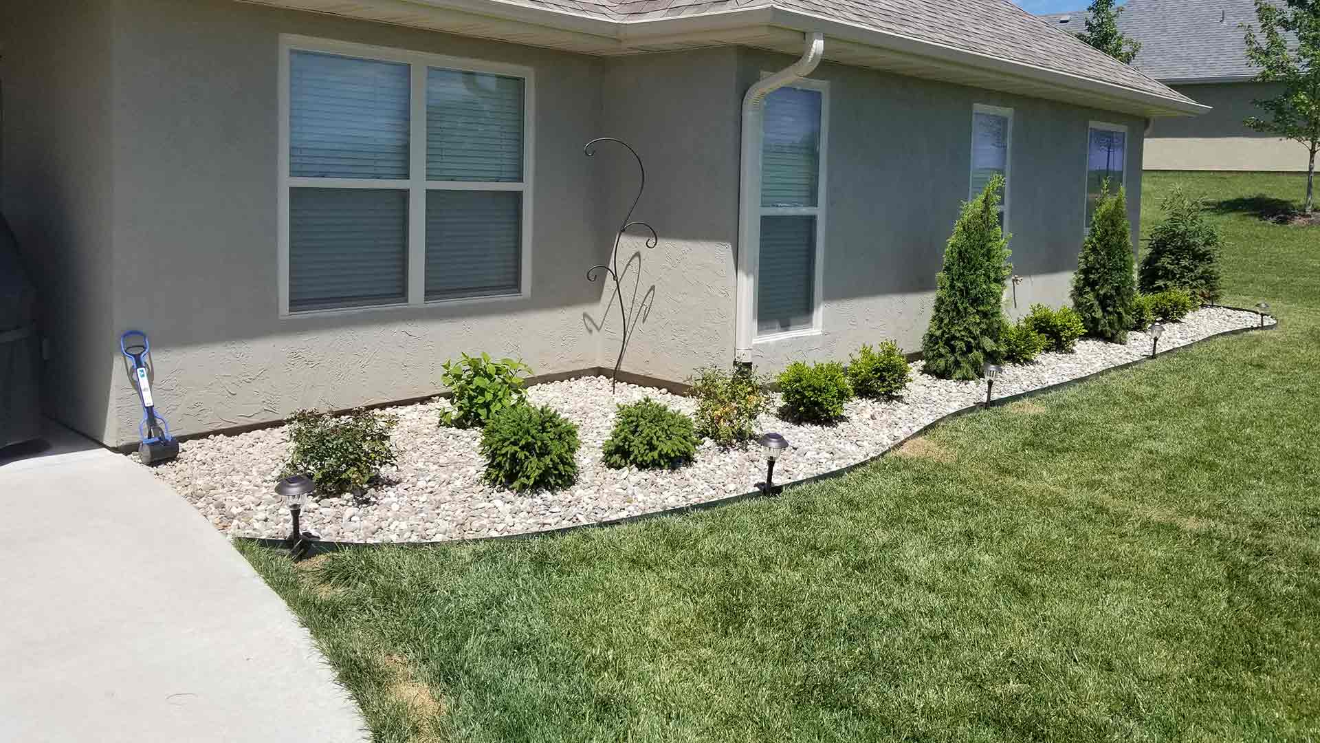 Columbia, MO home with freshly pruned bushes and rock installed by McVey Mowing.