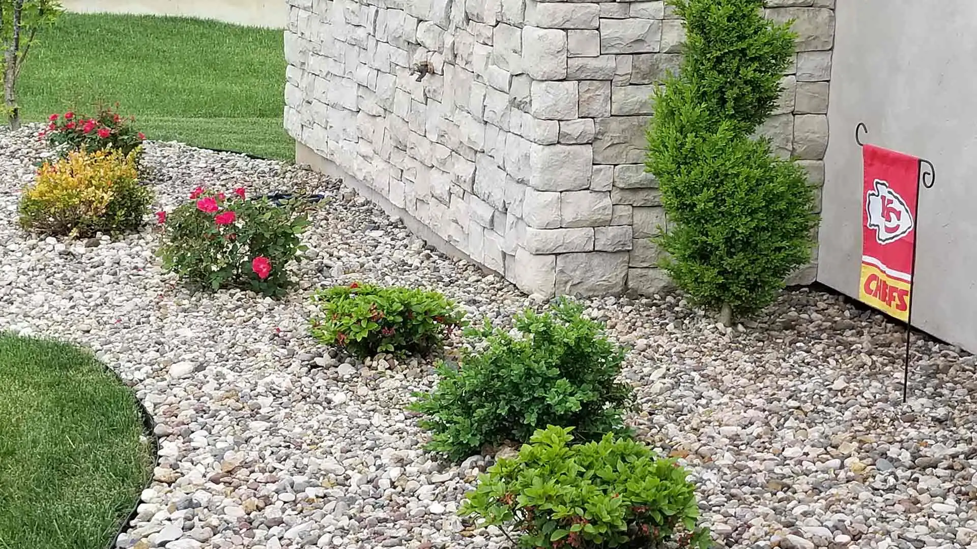 Ground covering by McVey Mowing at Columbia, MO home's front yard with flowers and river gravel.