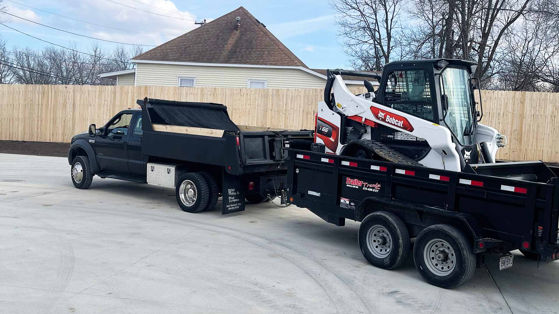 McVey Mowing work truck and trailer towing equipment to a landscaping job in Columbia, MO.